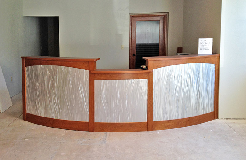 A new curved reception desk for Northland EyeCare of Flagstaff Az.  The desk features a curved design, brushed stainless laminate and cherry stained wood.