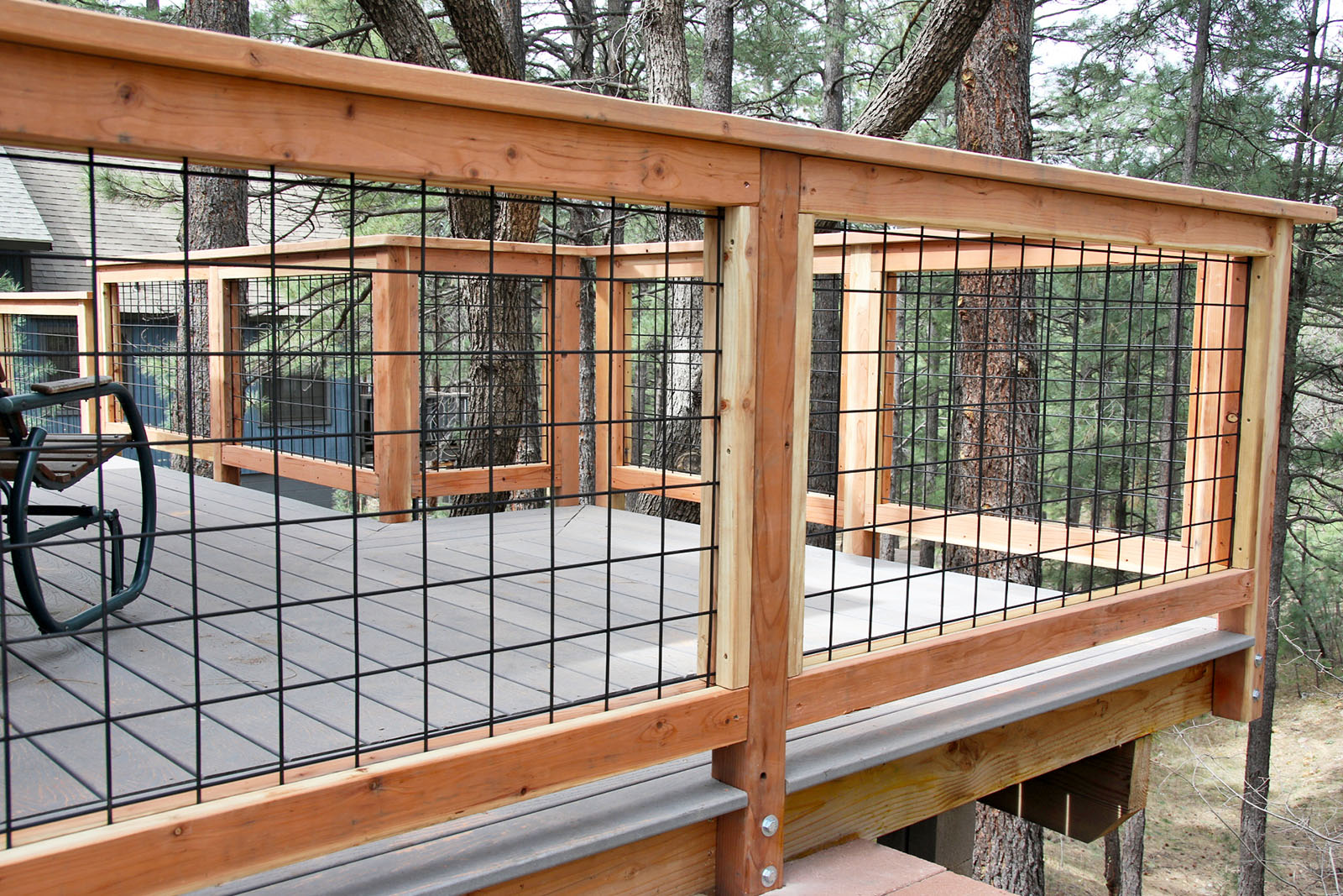 Wild Hog brand metal deck railing installed on a deck in Kachina Village near Flagstaff Arizona.  The railing consists of black painted welded wire on a 4 inch by 4 inch grid.