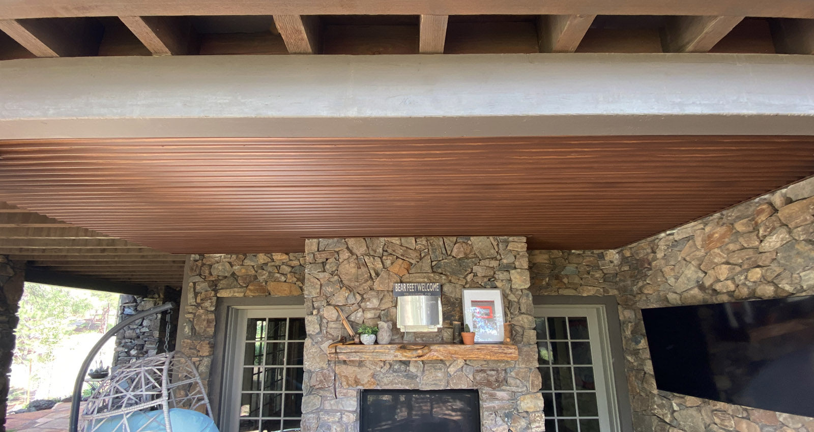 under deck waterproof outdoor living area created by installin corrugated panels to the underside of the deck joists.