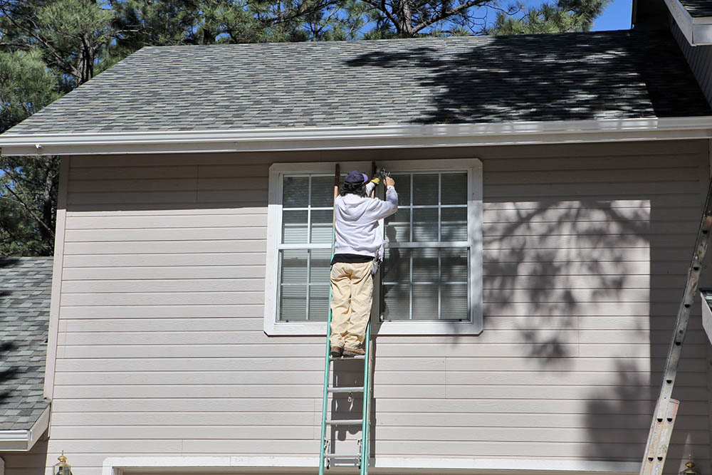 Caulking windows on an exterior paint job in Flagstaff AZ
