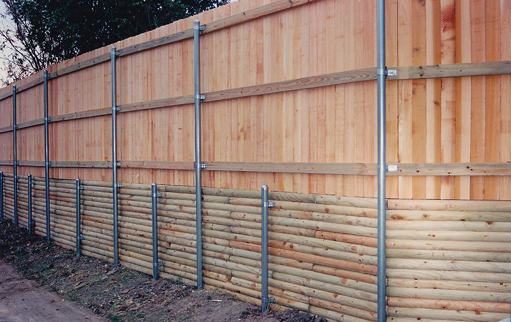 Custom fence with a treated lumber retaining wall and metal posts