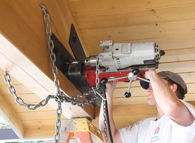 Using a magnetic drill press to install new bolt holes in a beam bracket