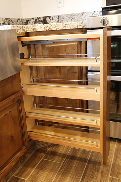 Hidden spice rack behind a filler strip in new kitchen cabinets.
